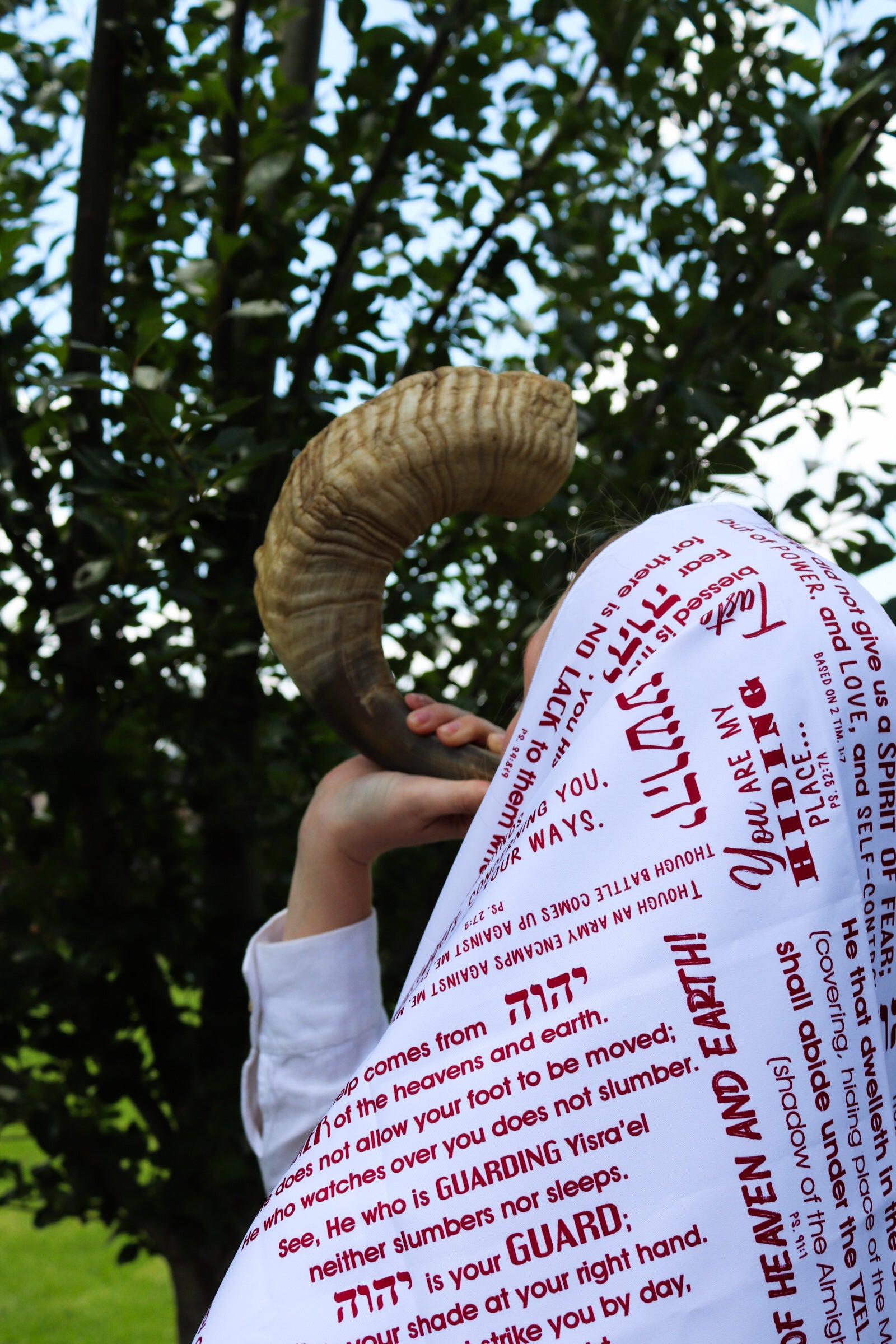 person wearing red protection faith wrap with scripture during prayer outdoors